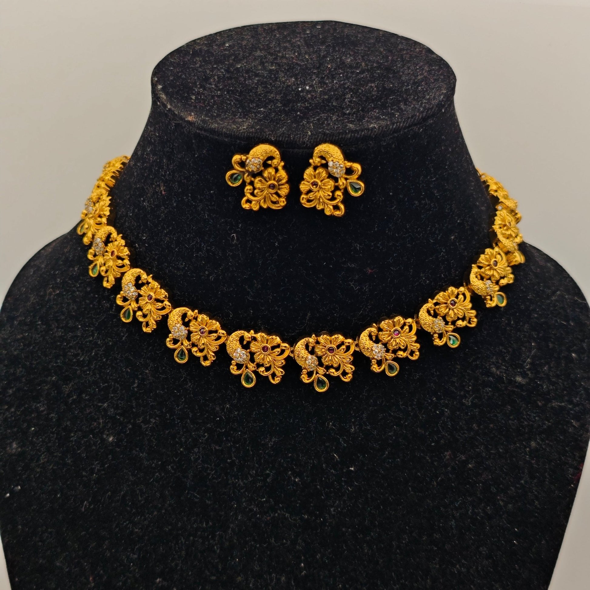 Adrika Antique Gold Plated Temple Choker Necklace Set with Floral Motifs and Emerald Accents – Traditional Ethnic Jewelry MGNS315 - The Soul Jewellery