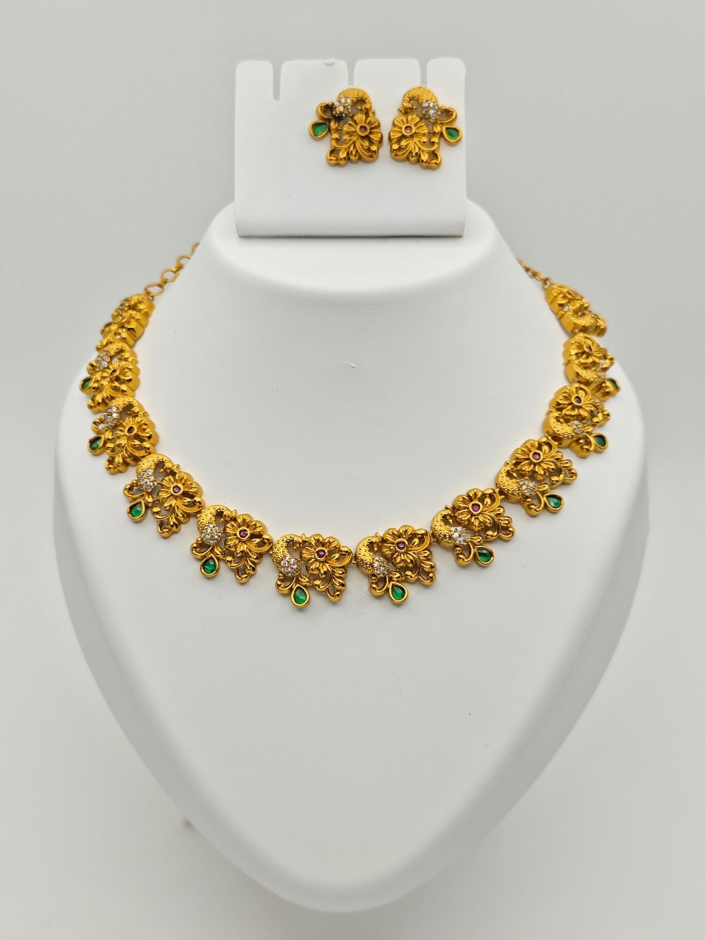 Adrika Antique Gold Plated Temple Choker Necklace Set with Floral Motifs and Emerald Accents – Traditional Ethnic Jewelry MGNS315 - The Soul Jewellery